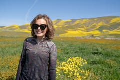 A posição da jovem mulher em um campo levanta durante a flor super no monumento nacional liso de Carrizo em Califórnia Óculos de fotografia de stock A posição da jovem mulher em um campo levanta durante a flor super no monumento nacional liso de Carrizo em Califórnia Óculos de fotografia de stock