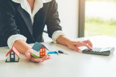 Posse do mediador imobiliário das mulheres um modelo da casa pequena em sua mão, com referência a fotografia de stock Posse do mediador imobiliário das mulheres um modelo da casa pequena em sua mão, com referência a fotografia de stock