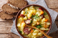 Potage aux légumes allemand délicieux de pomme de terre avec des saucisses dans une cuvette c photographie stock libre de droits Potage aux légumes allemand délicieux de pomme de terre avec des saucisses dans une cuvette c photographie stock libre de droits