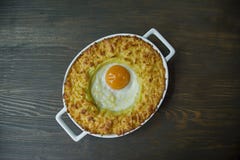 Potatiseldfast form med bolognese Bakad potatiseldfast form med ?gget och grated ost i en keramisk oval bakpl?t Tr?m?rker royaltyfri foto Potatiseldfast form med bolognese Bakad potatiseldfast form med ?gget och grated ost i en keramisk oval bakpl?t Tr?m?rker royaltyfri foto