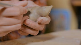 Potier de femme faisant le penny en c?ramique de souvenir siffler dans l'atelier de poterie clips vidéos Potier de femme faisant le penny en c?ramique de souvenir siffler dans l'atelier de poterie clips vidéos