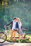 Potomstwa dobieraj? si?, przystojny m??czyzna i atrakcyjna kobieta na tandemowym rowerze w pogodnym lato parku, lesie lub zdjęcia stock Potomstwa dobieraj? si?, przystojny m??czyzna i atrakcyjna kobieta na tandemowym rowerze w pogodnym lato parku, lesie lub zdjęcia stock