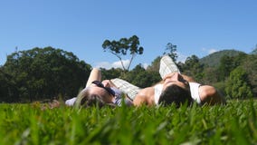 Potomstwa dobierają się lying on the beach na zielonej trawie w parkowym i relaksującym Mężczyzna i kobiety obsiadanie na łące pr fotografia royalty free Potomstwa dobierają się lying on the beach na zielonej trawie w parkowym i relaksującym Mężczyzna i kobiety obsiadanie na łące pr fotografia royalty free