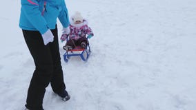 Potomstwo matka stacza się małego dziecka na saniu wzdłuż śnieżnej drogi w zimie Dziecko jest niegrzeczny i płacze podczas gdy si zdjęcie wideo Potomstwo matka stacza się małego dziecka na saniu wzdłuż śnieżnej drogi w zimie Dziecko jest niegrzeczny i płacze podczas gdy si zdjęcie wideo