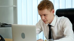 Potomstwo męczący biznesmen pracuje w jego biurze przed laptopem patrzeje skołowanym i będącym ubranym out zdjęcie wideo Potomstwo męczący biznesmen pracuje w jego biurze przed laptopem patrzeje skołowanym i będącym ubranym out zdjęcie wideo