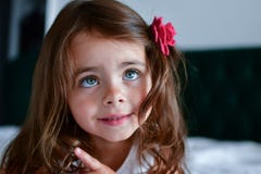 Pouca menina dos sorrisos com uma flor em seu cabelo fotos de stock royalty free Pouca menina dos sorrisos com uma flor em seu cabelo fotos de stock royalty free