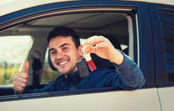 Pouce d'apparence de conducteur de type vers le haut de geste et du sourire positifs photographie stock Pouce d'apparence de conducteur de type vers le haut de geste et du sourire positifs photographie stock