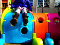 Pouco otudoor do jogo de criança em um campo de jogos com um brinquedo, um divertimento e um conceito coloridos do jogo fotos de stock Pouco otudoor do jogo de criança em um campo de jogos com um brinquedo, um divertimento e um conceito coloridos do jogo fotos de stock