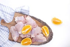 Poulet avec des oranges crues sur un conseil en bois et une table blanche Préparation d'un dîner de viande délicieux Vue supérieu photographie stock Poulet avec des oranges crues sur un conseil en bois et une table blanche Préparation d'un dîner de viande délicieux Vue supérieu photographie stock