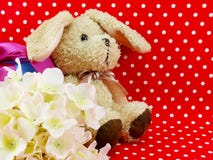 Poupée de lapin avec le boîte-cadeau rose de coeur et la fleur artificielle sur le fond rouge de point de polka Images libres de droits