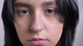 Pousse de plan rapproché du jeune joli visage femelle caucasien regardant directement la caméra avec le fond d'isolement banque de vidéos Pousse de plan rapproché du jeune joli visage femelle caucasien regardant directement la caméra avec le fond d'isolement banque de vidéos