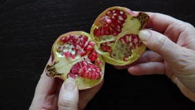 Jewish woman opens a fresh Pomegranate fruit