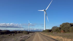 Pov walking toward large wind turbine on a sunny day. stock video Pov walking toward large wind turbine on a sunny day. stock video