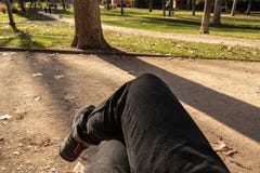 POV ног человека пересек сидеть на стенде в на открытом воздухе парке стоковое фото rf POV ног человека пересек сидеть на стенде в на открытом воздухе парке стоковое фото rf