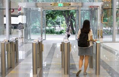 Povos das mulheres que andam para fora da segurança em uma porta da entrada com prédio de escritórios esperto do controle de aces foto de stock Povos das mulheres que andam para fora da segurança em uma porta da entrada com prédio de escritórios esperto do controle de aces foto de stock