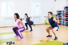 Povos que fazem ocupas com os barbells nos ombros que exercitam no clube de aptidão fotos de stock Povos que fazem ocupas com os barbells nos ombros que exercitam no clube de aptidão fotos de stock