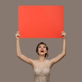 Powabna szcz??liwa kobieta trzyma du?ego czerwie? papieru pustego puste miejsce obraz stock Powabna szcz??liwa kobieta trzyma du?ego czerwie? papieru pustego puste miejsce obraz stock