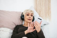 Pozytywna starsza kobieta słucha muzyka Stare nowe technologie i pokolenie obraz stock Pozytywna starsza kobieta słucha muzyka Stare nowe technologie i pokolenie obraz stock