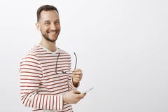 Pozytywny pomyślny męski biznesmen, brać daleko szkła, patrzeć na boku i ono uśmiecha się życzliwego, podnoszący muzykę słuchać w fotografia stock Pozytywny pomyślny męski biznesmen, brać daleko szkła, patrzeć na boku i ono uśmiecha się życzliwego, podnoszący muzykę słuchać w fotografia stock