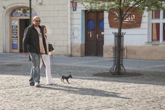 Praag, Tsjechische Republiek - 19 April, 2011: Een paar loopt in het vierkant met haar weinig hond Zij stellen voor een foto stock fotografie Praag, Tsjechische Republiek - 19 April, 2011: Een paar loopt in het vierkant met haar weinig hond Zij stellen voor een foto stock fotografie