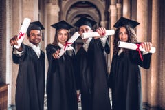 Pracowaliśmy mocno i dostać rezultaty! Grupa ono uśmiecha się kończy studia pokazywać ich dyplomy w uniwersyteckiej sali i patrze obraz royalty free Pracowaliśmy mocno i dostać rezultaty! Grupa ono uśmiecha się kończy studia pokazywać ich dyplomy w uniwersyteckiej sali i patrze obraz royalty free
