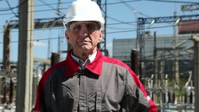 Pracownik w białym ciężkim kapeluszu przy zasilanie elektryczne stacją zbiory Pracownik w białym ciężkim kapeluszu przy zasilanie elektryczne stacją zbiory