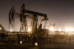 Pracująca nafcianej pompy dźwigarka przy nighttime obrazy stock Pracująca nafcianej pompy dźwigarka przy nighttime obrazy stock