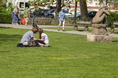 Praga, repubblica Ceca - 20 aprile 2011: Questo il ragazzo e l'amica stanno sedendo sull'erba succosa verde fotografia stock libera da diritti Praga, repubblica Ceca - 20 aprile 2011: Questo il ragazzo e l'amica stanno sedendo sull'erba succosa verde fotografia stock libera da diritti