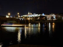 Praga, República Checa - 31 de outubro de 2018 exposição longa de um cruzamento do barco abaixo do arco de uma ponte no rio de Vl imagem de stock Praga, República Checa - 31 de outubro de 2018 exposição longa de um cruzamento do barco abaixo do arco de uma ponte no rio de Vl imagem de stock