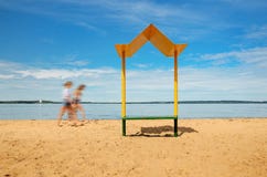 Praia vazia com um banco com um dossel na costa Imagens de Stock Praia vazia com um banco com um dossel na costa Imagens de Stock