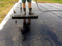 Praimer битума работника Roofer крася на конкретной поверхности делать водостойким щетки ролика стоковое фото rf Praimer битума работника Roofer крася на конкретной поверхности делать водостойким щетки ролика стоковое фото rf