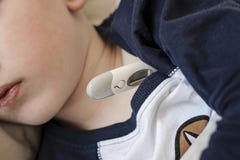 Pre-school sick boy lying on pillow in bed with a digital thermometer. Ill boy is measuring body temperature - close up royalty free stock photography Pre-school sick boy lying on pillow in bed with a digital thermometer. Ill boy is measuring body temperature - close up royalty free stock photography