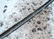 Precio de la tranvía en invierno en la ciudad Las huellas de los peatones que cruzan el metal cercan el fondo con barandilla foto de archivo libre de regalías Precio de la tranvía en invierno en la ciudad Las huellas de los peatones que cruzan el metal cercan el fondo con barandilla foto de archivo libre de regalías