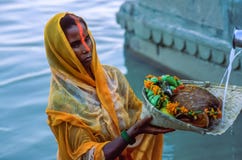Preghiere d'offerta del patito indù indiano della donna al Sun Dio durante il Chhath Puja a Varanasi fotografia stock libera da diritti Preghiere d'offerta del patito indù indiano della donna al Sun Dio durante il Chhath Puja a Varanasi fotografia stock libera da diritti