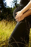 Pregnant Couple In Grass Royalty Free Stock Images