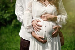 Pregnant Couple Posing In Park In Summer Day. Stock Photo