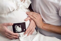 Pregnant girl holding with their hands the belly and the husband keeps the hand in the ultrasound royalty free stock image Pregnant girl holding with their hands the belly and the husband keeps the hand in the ultrasound royalty free stock image