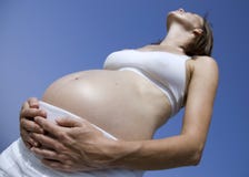 Pregnant Girl Standing Up Against A Blue Sky Royalty Free Stock Photo