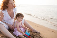 Pregnant mother and daughter playing in beach sand Royalty Free Stock Photos Pregnant mother and daughter playing in beach sand Royalty Free Stock Photos