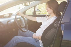 Pregnant pretty young woman is sitting in car royalty free stock photo Pregnant pretty young woman is sitting in car royalty free stock photo