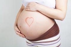 Pregnant woman belly with heart drawn