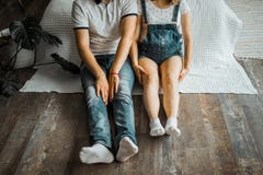 A pregnant woman with a belly and her husband sitting on the couch and holding hands. stock images A pregnant woman with a belly and her husband sitting on the couch and holding hands. stock images