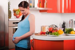 Pregnant woman in kitchen stock photos Pregnant woman in kitchen stock photos