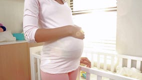 Pregnant woman looking at new cot