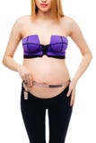 Pregnant woman measuring her big pregnant belly with measuring families. Mom Is Expecting A Baby. The concept of Royalty Free Stock Photos Pregnant woman measuring her big pregnant belly with measuring families. Mom Is Expecting A Baby. The concept of Royalty Free Stock Photos