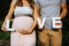pregnant woman and her husband holding the letters for love in their hands with royalty free stock image pregnant woman and her husband holding the letters for love in their hands with royalty free stock image