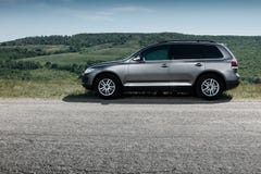 Premium car stay on asphalt road near mountain at daytime. Premium grey car stay on asphalt road near mountain at daytime Royalty Free Stock Images Premium car stay on asphalt road near mountain at daytime. Premium grey car stay on asphalt road near mountain at daytime Royalty Free Stock Images