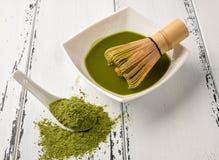 Preparación del partido del té: rueda con bate y la taza de té, polvo del partido del té verde en una cuchara de cerámica blanca imagenes de archivo Preparación del partido del té: rueda con bate y la taza de té, polvo del partido del té verde en una cuchara de cerámica blanca imagenes de archivo