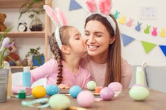 Preparazione di pasqua della figlia e della madre insieme a casa in orecchie del coniglietto che si siedono ragazza che bacia mam fotografia stock libera da diritti Preparazione di pasqua della figlia e della madre insieme a casa in orecchie del coniglietto che si siedono ragazza che bacia mam fotografia stock libera da diritti