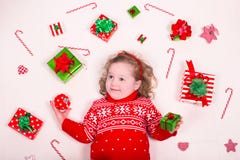 Presentes de Natal da abertura da menina foto de stock royalty free Presentes de Natal da abertura da menina foto de stock royalty free
